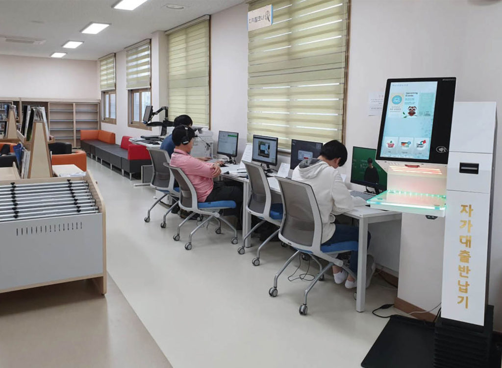 Selfcheck 1000 and people on computers in Haenam library