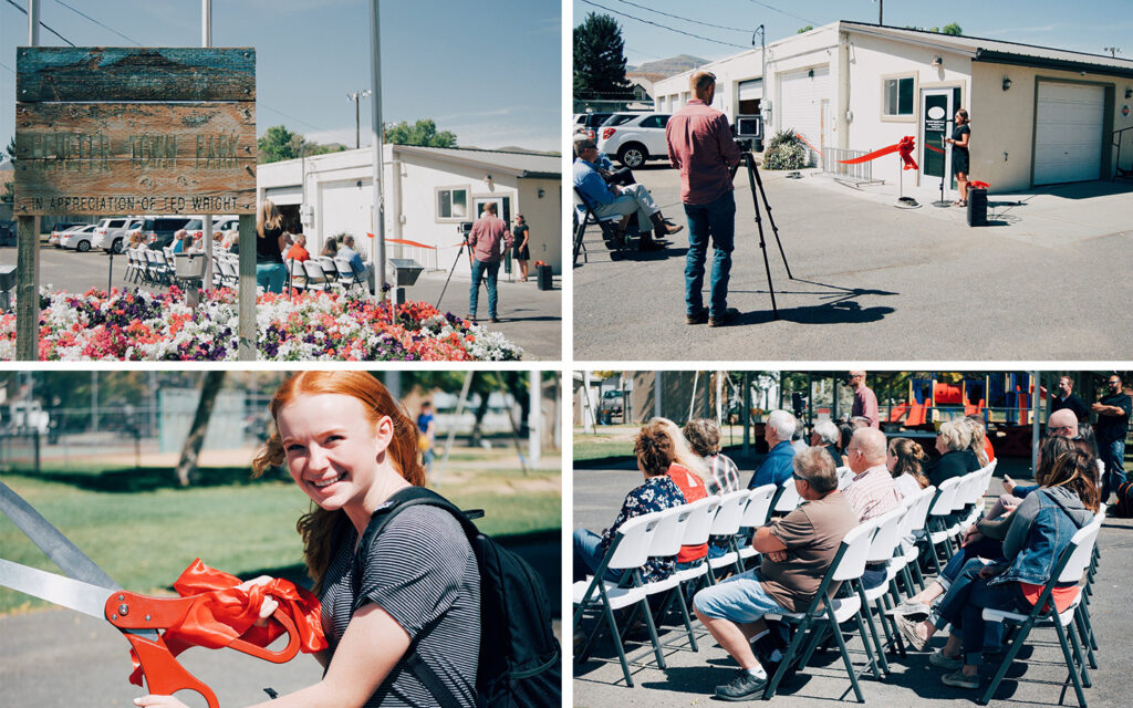Ribbon cutting ceremony at Henefer for the Summit County Library's new remoteLocker, featuring attendees seated outdoors, a cameraman recording the event, and a young woman smiling while holding large ceremonial scissors.